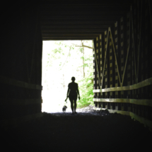 woman walking through tunnel